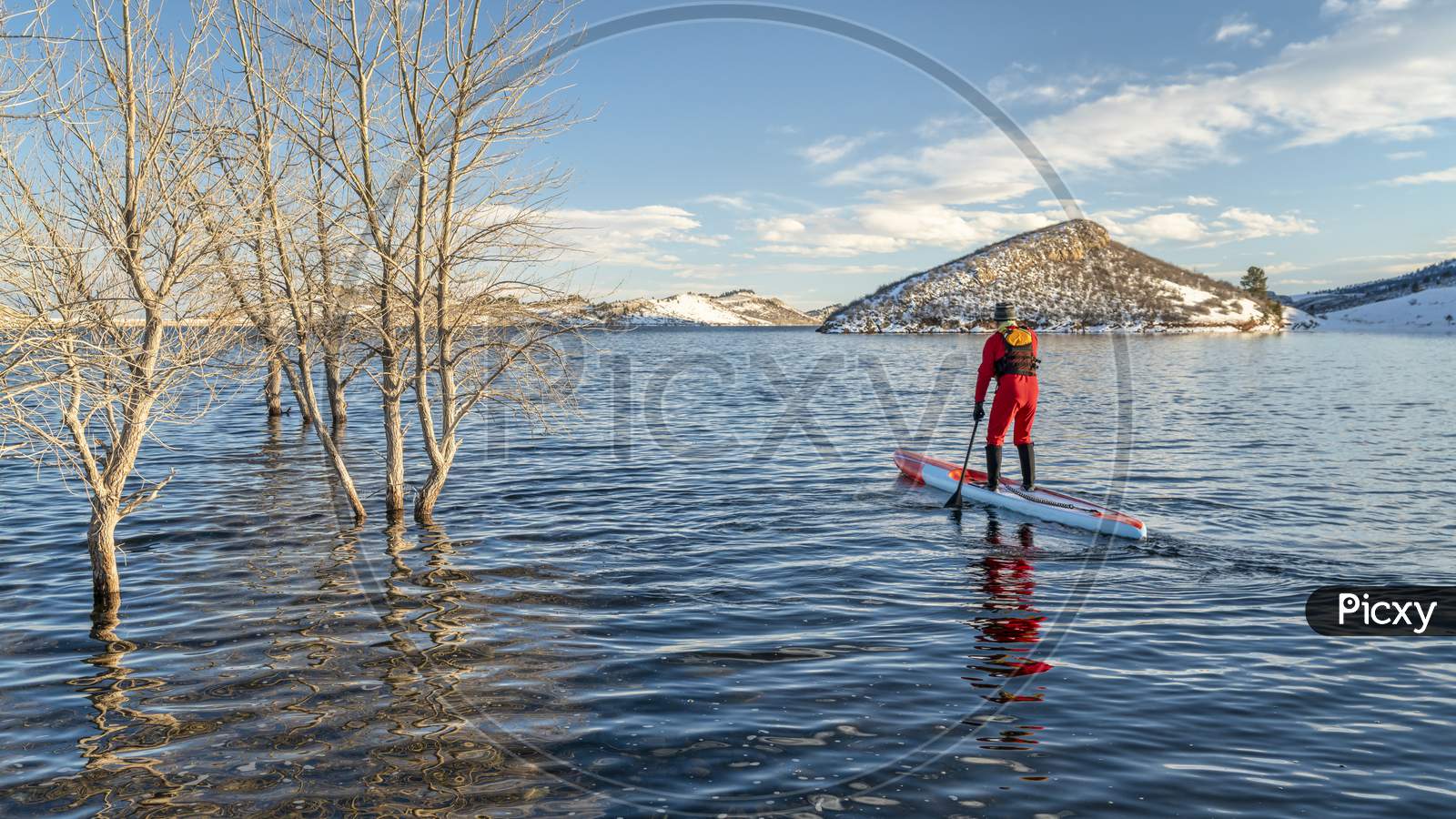 Male Paddler In A Drysuit And Life Jacket Is Paddling A Long Racing Stand Up Paddleboard In Winter Conditions On A Lake In Colorado - Horsetooth Reservoir, Fitness And Training Concept