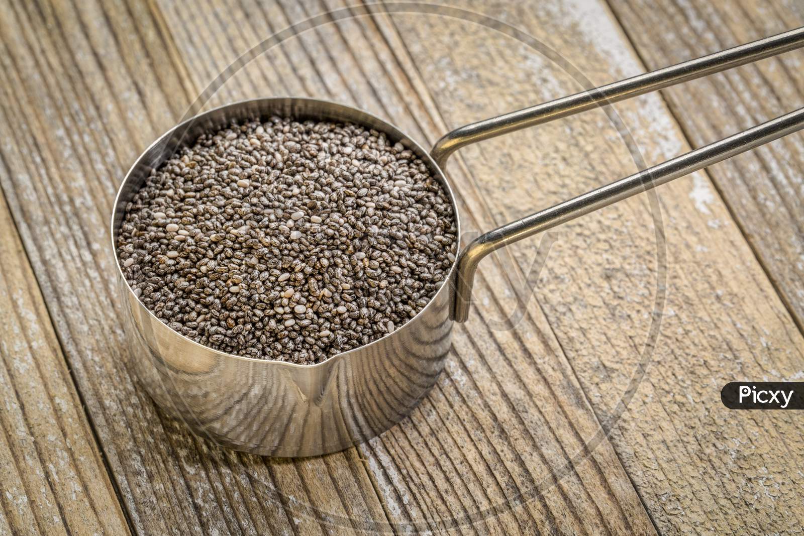 Chia Seeds In Metal Measuring Scoop Against Grunge Wood Background, Healthy Superfood Concept