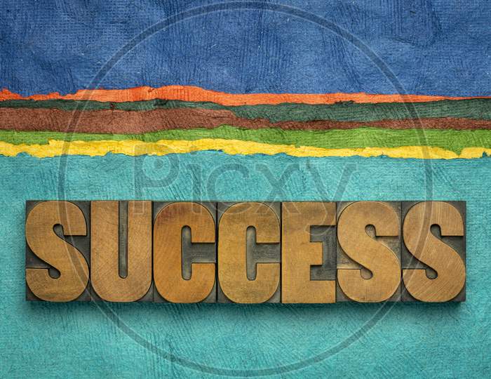Success Word Abstract In Vintage Letterpress Wood Type Against Colorful Abstract Paper Landscape