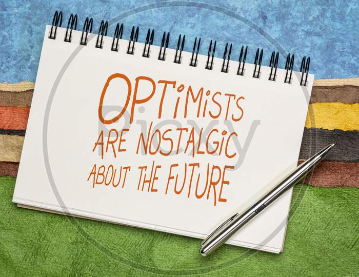 Optimists Are Nostalgic About The Future  Inspirational Quote - Handwriting In A Sketchbook Against Colorful Abstract Landscape.  Positivity Concept.