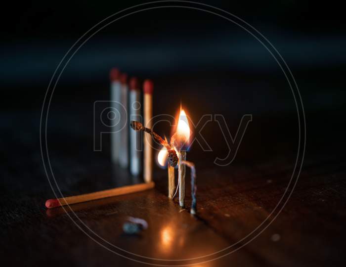 Burning matchstick on black background
