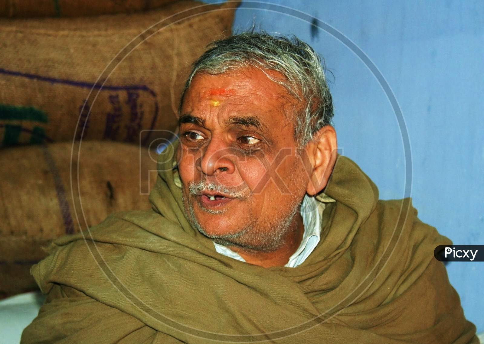 Aged Indian man portrait, sitting at shop in Jaipur.