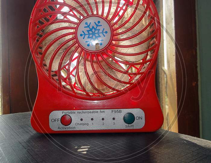 A Small Hand Fan At The Home On The Table