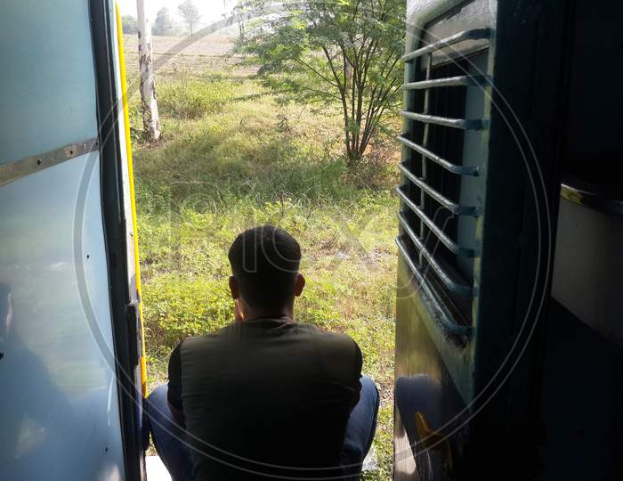 Passenger travelling on footboard of moving train