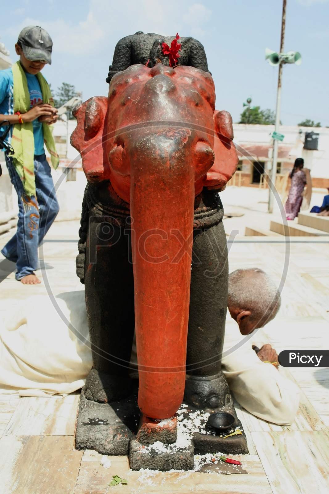 Elderly man passing under the elephant in Narmada mandir, at Amarkantak, Madhya pradesh
