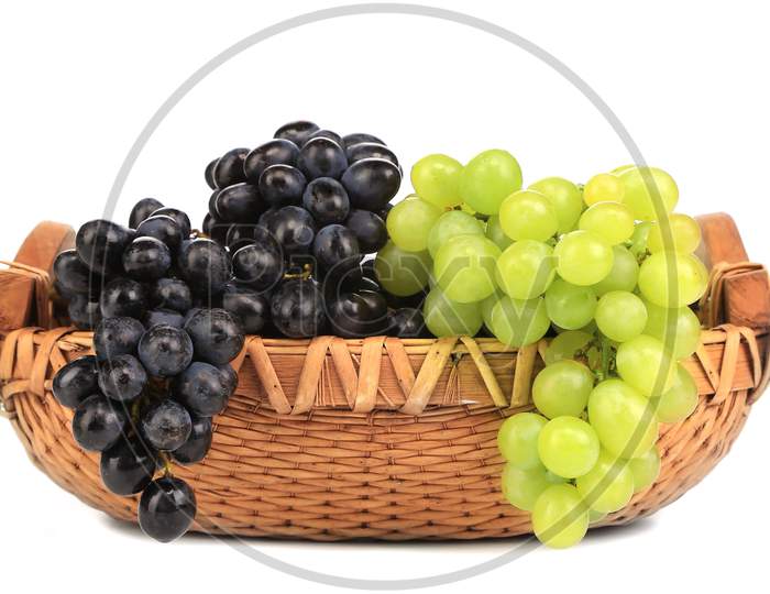 Black And Green Grapes In Basket. Isolated On A White Background.