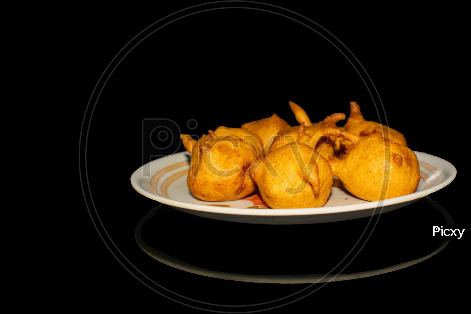 Batata vada in plate with black background front view