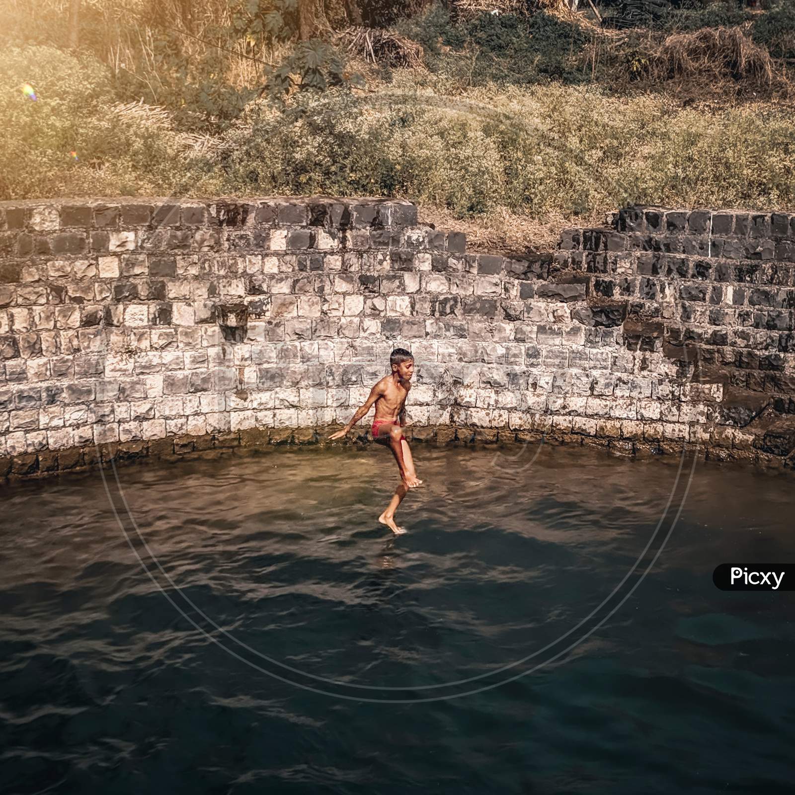 A boy jumping in a well