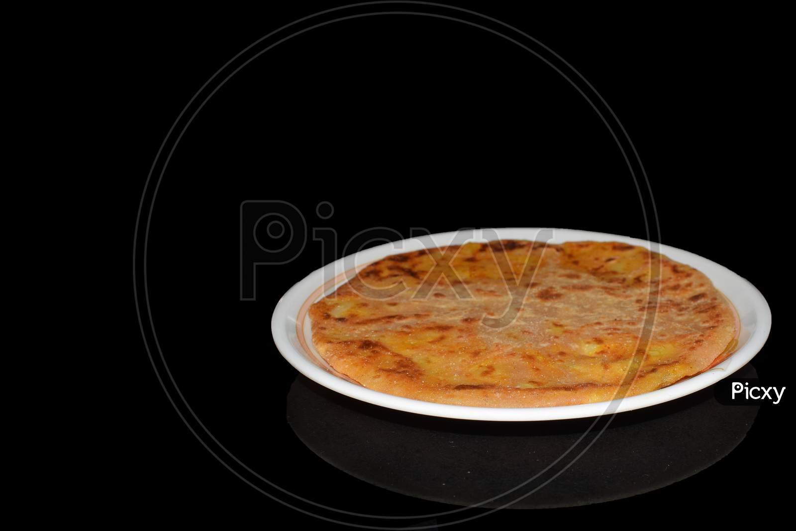 Aloo parantha in plate with black background front view