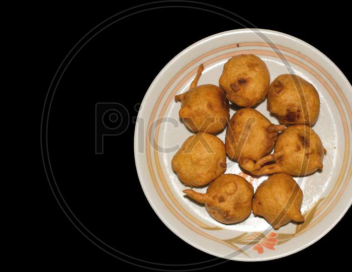 Batata vada in plate with black background top view