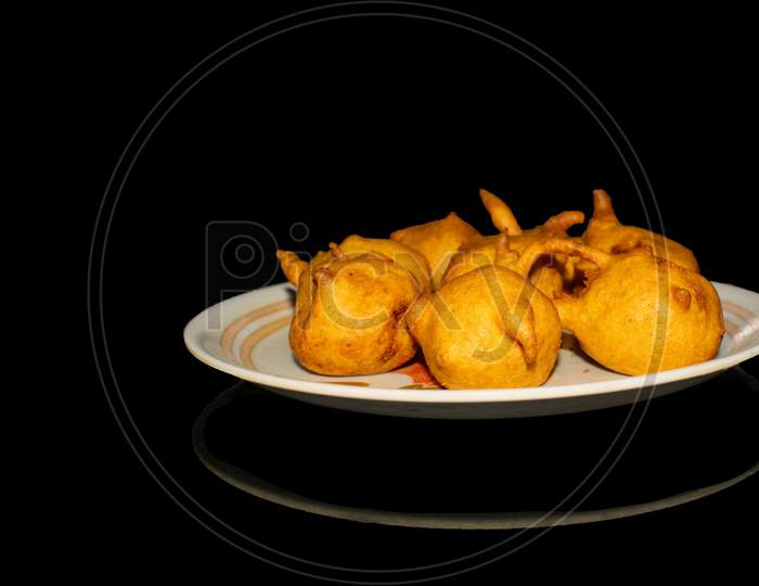 Batata vada in plate with black background front view