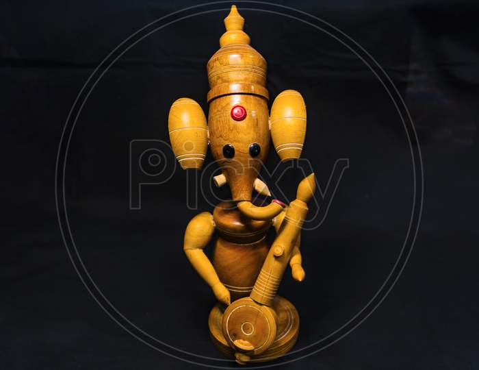 Wooden Lord Ganesha With Black Background And Selective Focus On Lord Ganesha .