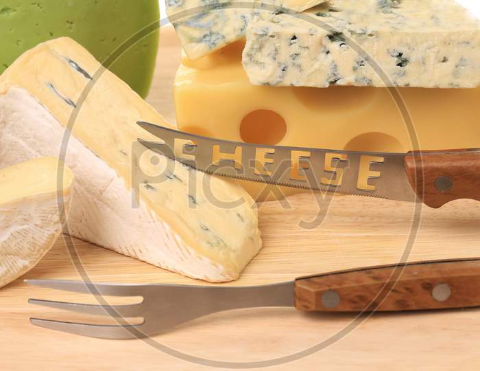 Various Types Of Cheeses On Wood. With Knife. Whole Background