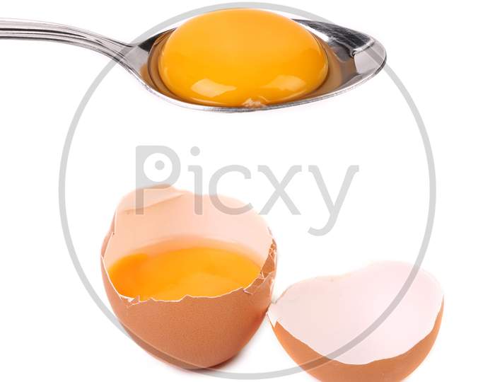 Egg Yolk On A Silver Spoon In Shell. Isolated On A White Background.