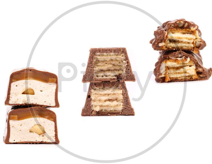Stacks Of Broken Chocolate Bars. Isolated On A White Background.