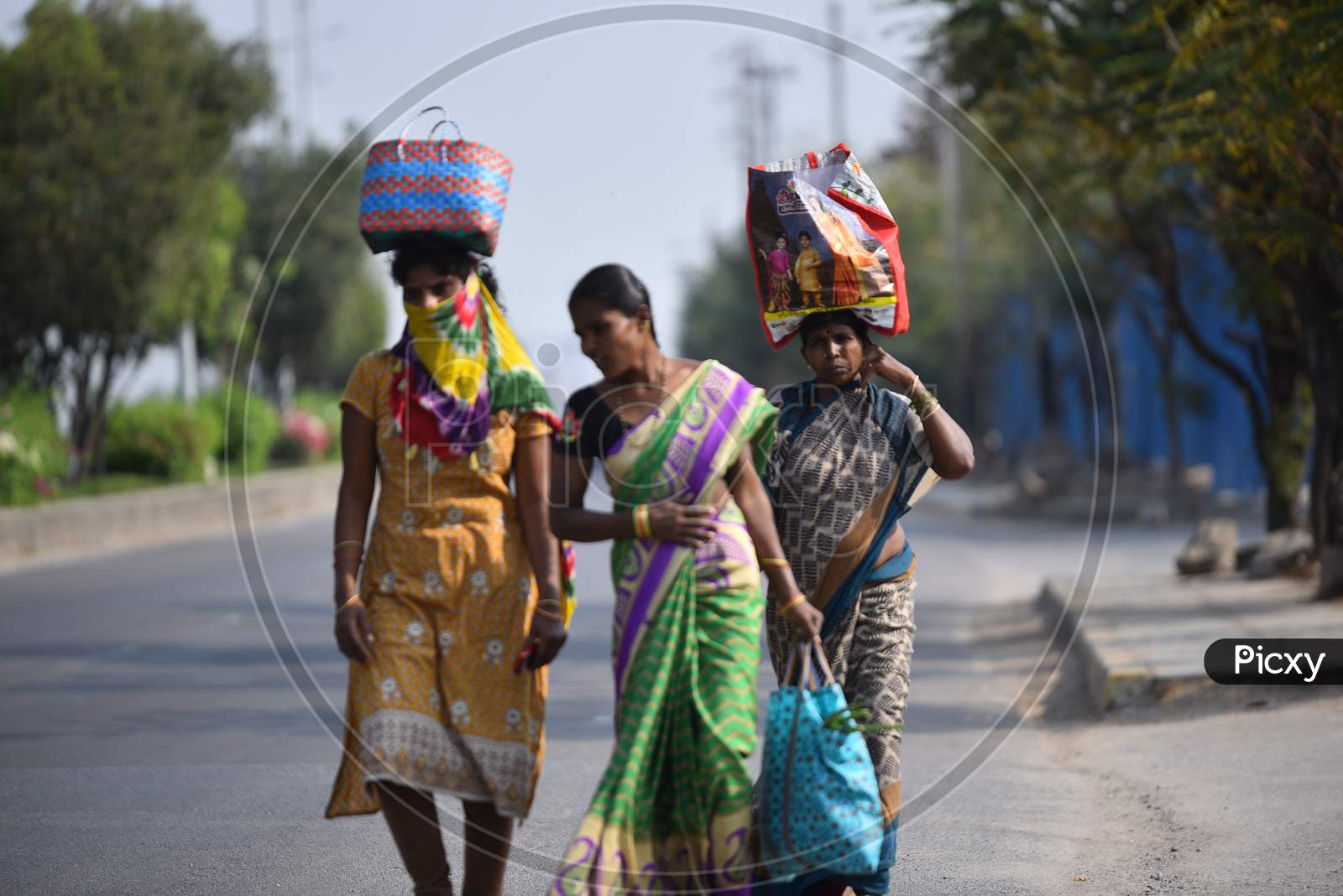 Women buy vegetables at a makeshift market at Hitech city MMTS station and walk towards Madhapur amid corona virus pandemic in Hyderabad