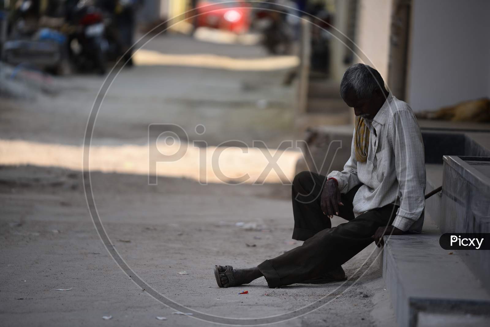 a homeless man sitting on steps amid nation wide lockdown in india due to corona virus pandemic