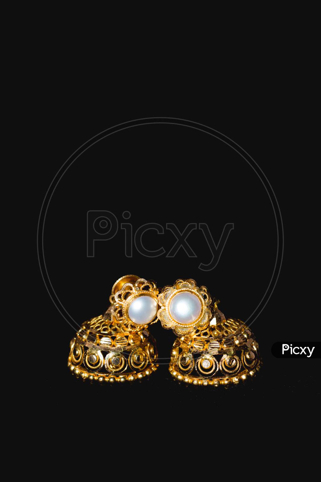 Earring Gold Jewelry Traditional With Stones And Two Golden Earrings With Reflection . Pair Of Golden Earring With Pearl Tone On Black Background. Luxury Female Jewelry, Close-Up