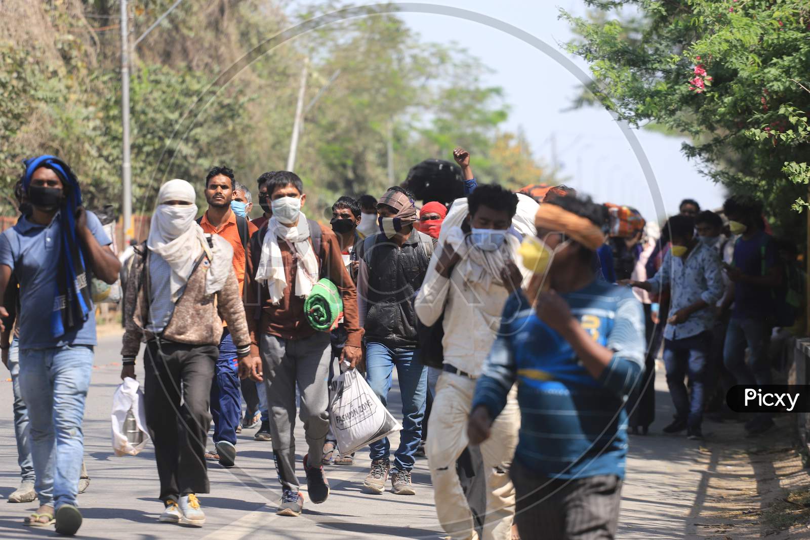 Migrant workers walk on the national highway as they return to their village during a 21-day nationwide lockdown to limit the spreading of coronavirus disease (COVID-19),  March 30, 2020.
