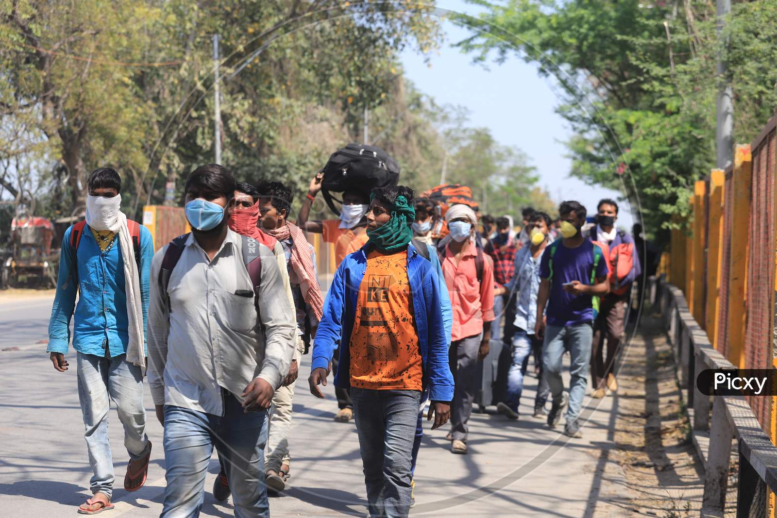 Migrant workers walk on the national highway as they return to their village during a 21-day nationwide lockdown to limit the spreading of coronavirus disease (COVID-19),  March 30, 2020.