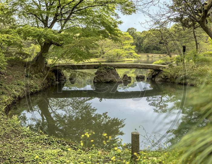 Japanese Togetsu Stone Bridge On The Pond Of Rikugien Park In Bunkyo District, North Of Tokyo. The Park Was Created At The Beginning Of The 18Th Century.