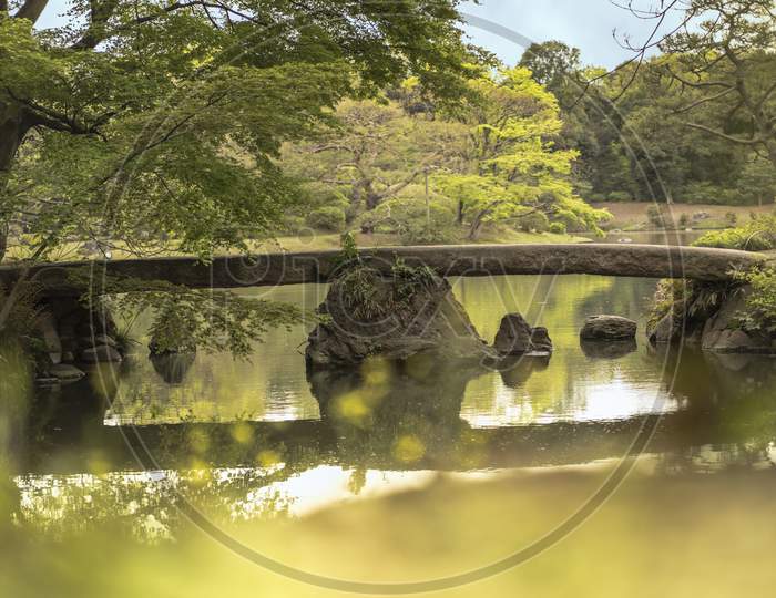 Japanese Togetsu Stone Bridge On The Pond Of Rikugien Park In Bunkyo District, North Of Tokyo. The Park Was Created At The Beginning Of The 18Th Century.