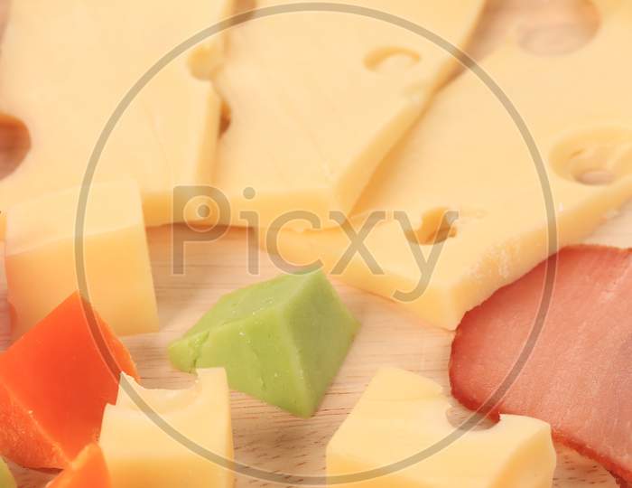 Various Types Of Cheese On Wooden Platter. Whole Background.