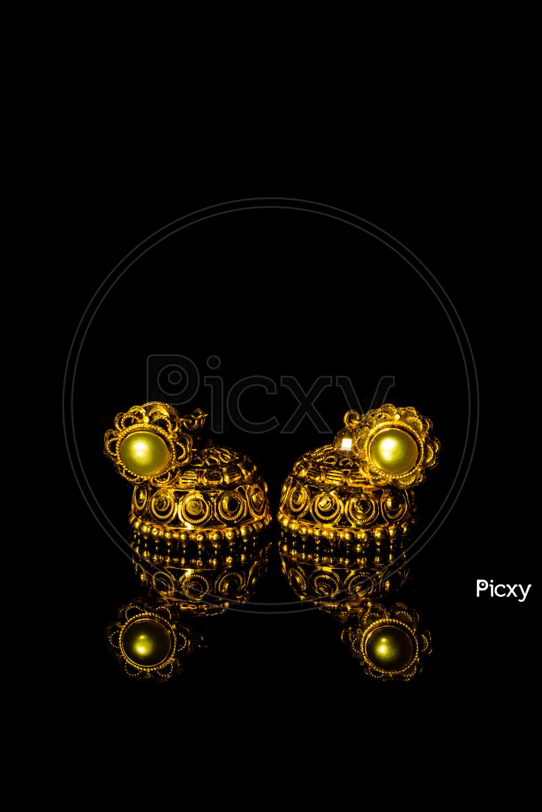 Earring Gold Jewelry Traditional With Stones And Two Golden Earrings With Reflection . Pair Of Golden Earring With Pearl Tone On Black Background. Luxury Female Jewelry, Close-Up