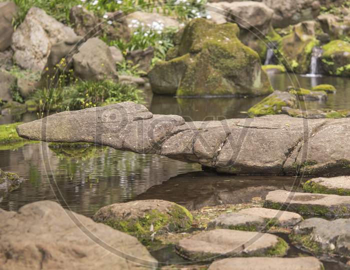 Stone Landscape Covered With Moss On The Pond Of Takimi Japanese Tea House Overlooking The Rikugien Park Garden In Bunkyo District, North Of Tokyo. The Park Was Created At The Beginning Of The 18Th Century.