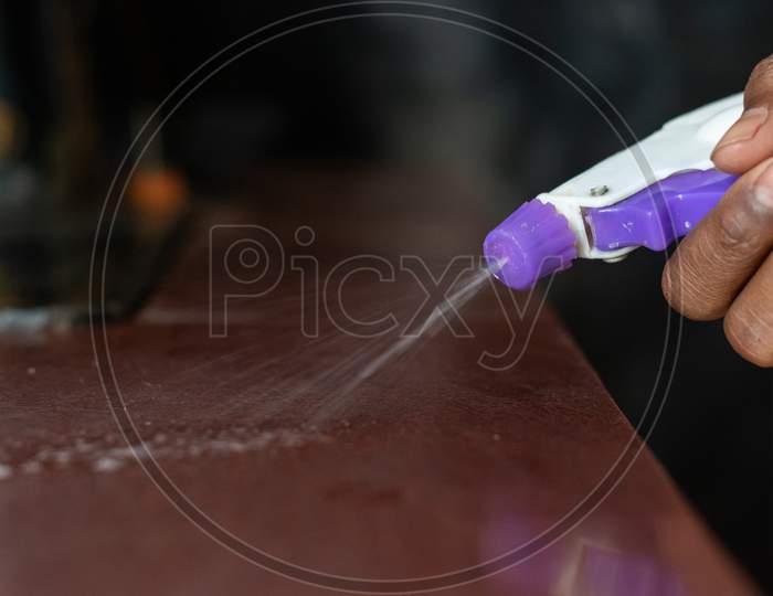 sanitizer is being sprayed on a surface to avoid the spread of corona virus covid 19