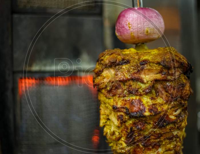 Fresh Shawarma With Tray Full Of Shawarmas. Shawarma Is One Of The Most Popular Fast Food Dish In Asian And Middle Eastern Countries.Closeup Picture Of Stacked Meat Roasting Chicken Shawarma