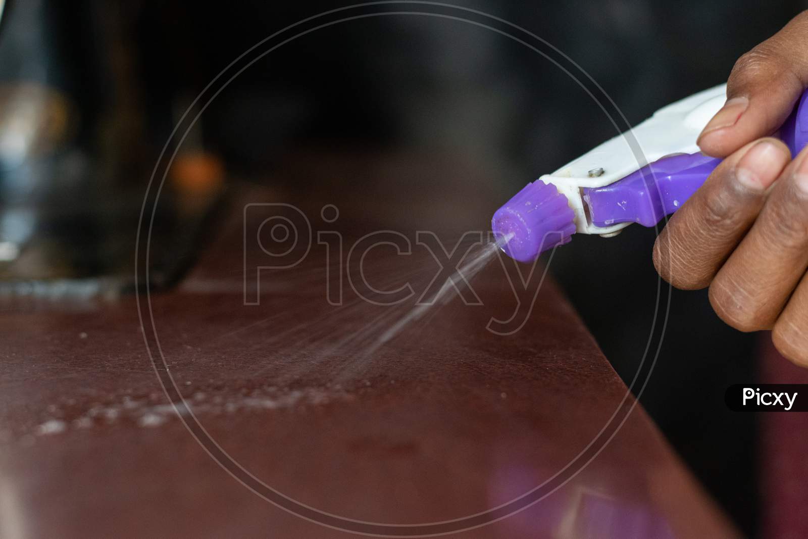 sanitizer is being sprayed on a surface to avoid the spread of corona virus covid 19