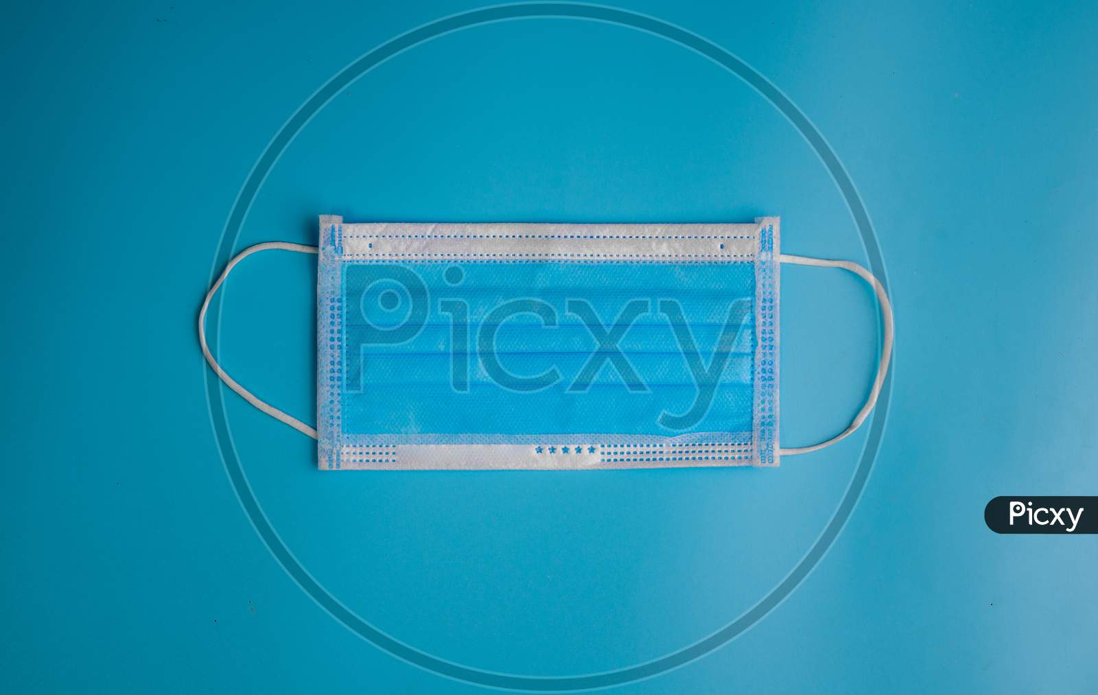 Blue Medical Disposable Face Mask With Covid-19 Printed On It. Covid-19 - Wuhan Novel Coronavirus Pneumonia Gets Official Name From Who: Covid-19. Disposable Breath Filter Face Mask With Earloop