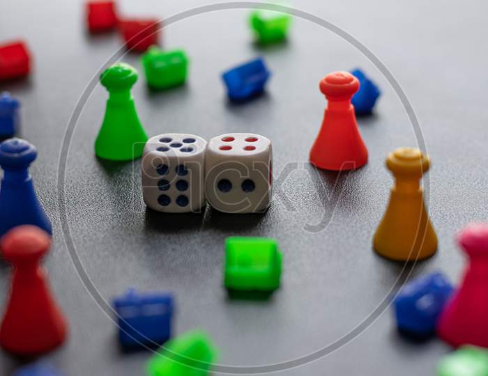 Colorful Plastic game pieces and dice used to play in monopoly game