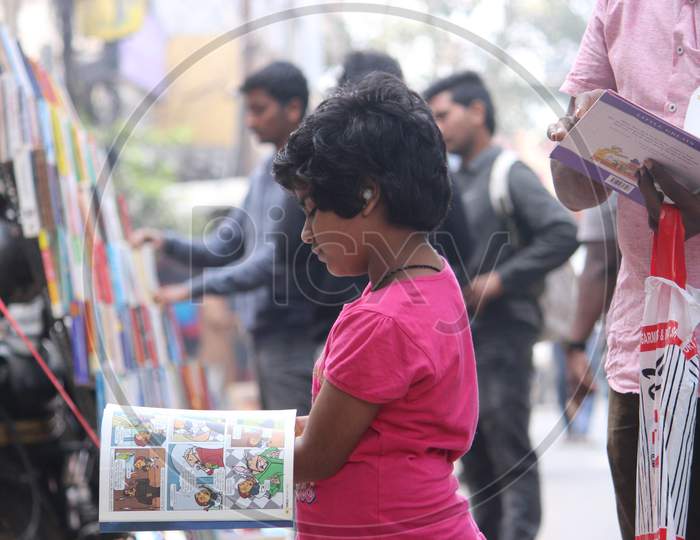 Girl reading book at ABIDS book market