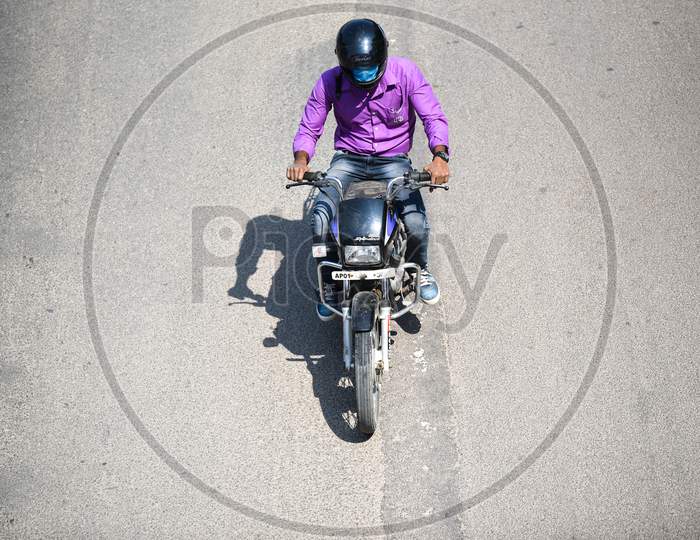 A man wearing protective face mask as he rides his bike.