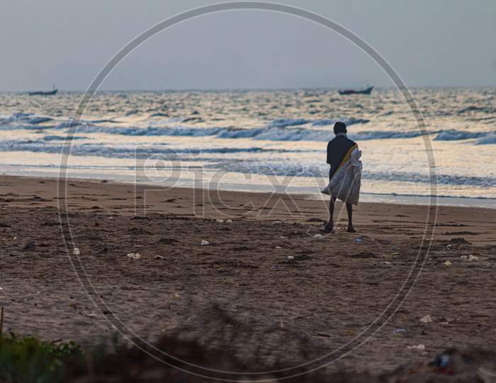 Boy Collecting waste in a beach