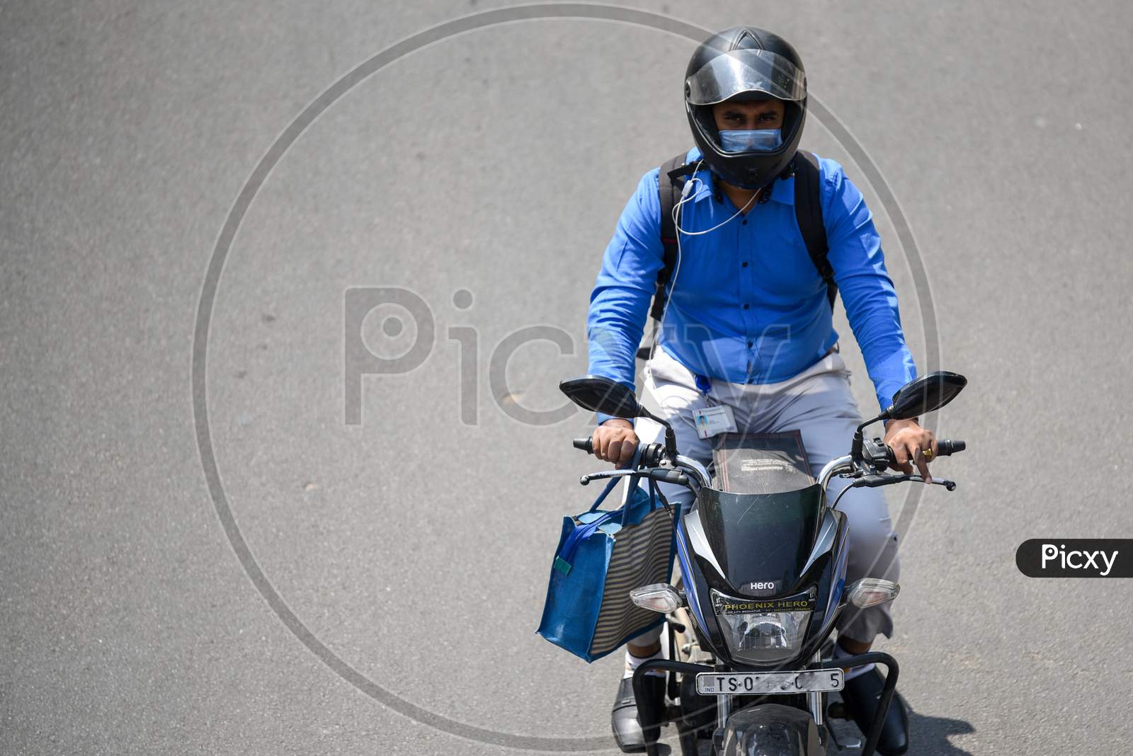 A man wearing the preventive pollution mask on his face as he rides his bike to protect himself from Novel Corona Virus, COVID-19