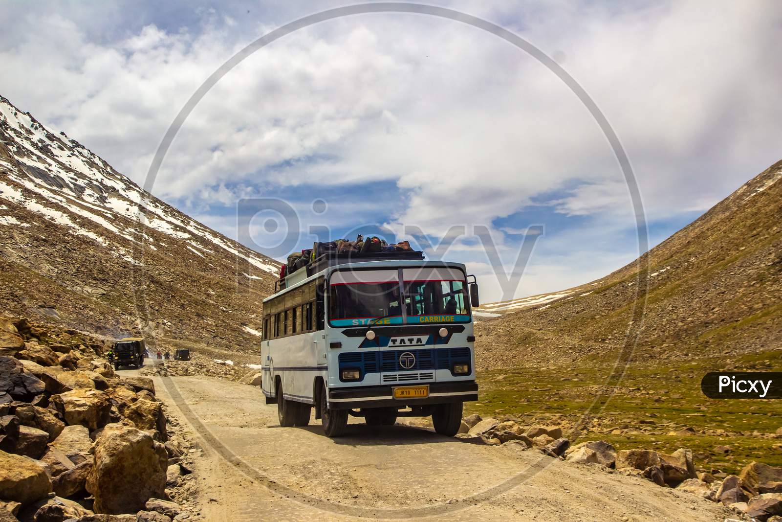 Ladakh,India.  A Public Bus Driving In Rocky Highway Surrounded By Himalayan Mountain During The Day At Ladakh, Kashmir, India.