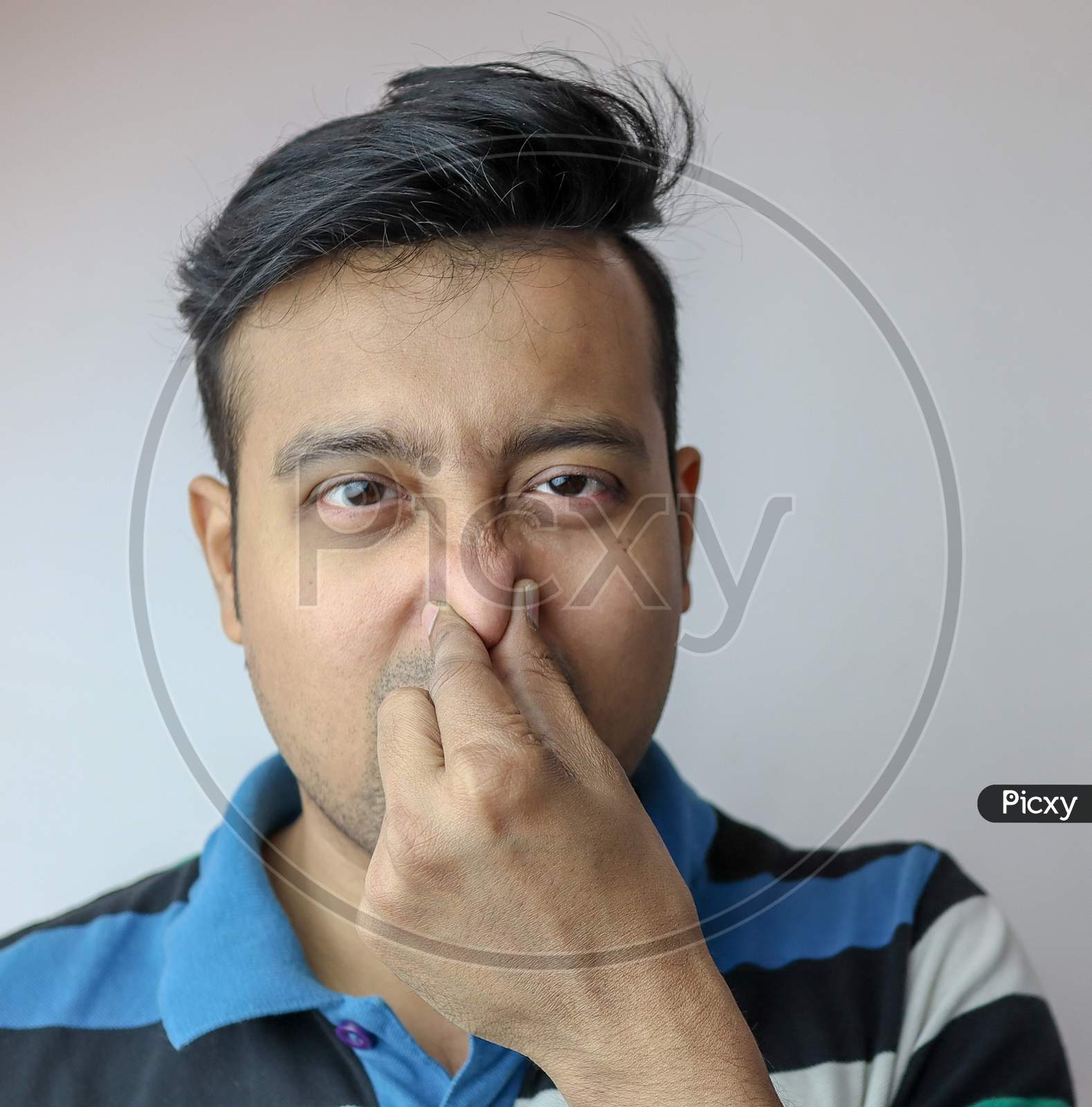 Image of A Young Indian Male Showing The Gesture Of Foul Smell Pinching