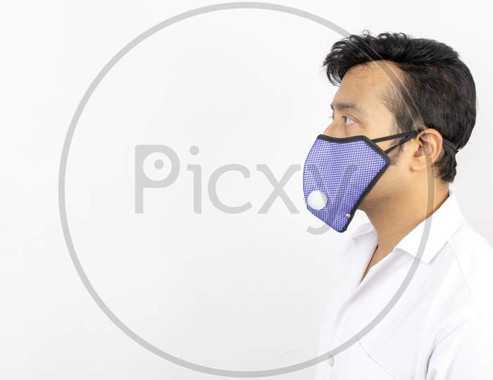 A Male Medical Professional In White Coat And Mask In White Background. View From Left. Concept Image For Viral Infection Precaution.