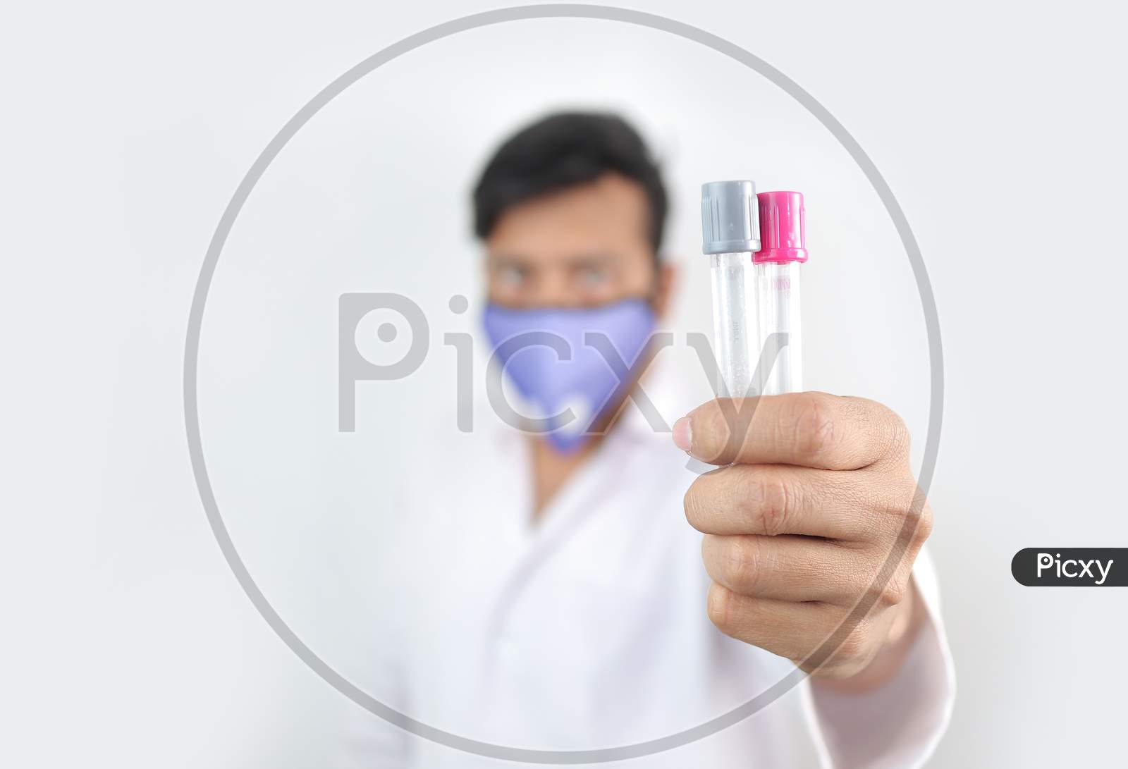A Medical Professional In White Coat And Protective Mask Holding Vials In Hand With Selective Focus In Hand With Blurred Background.