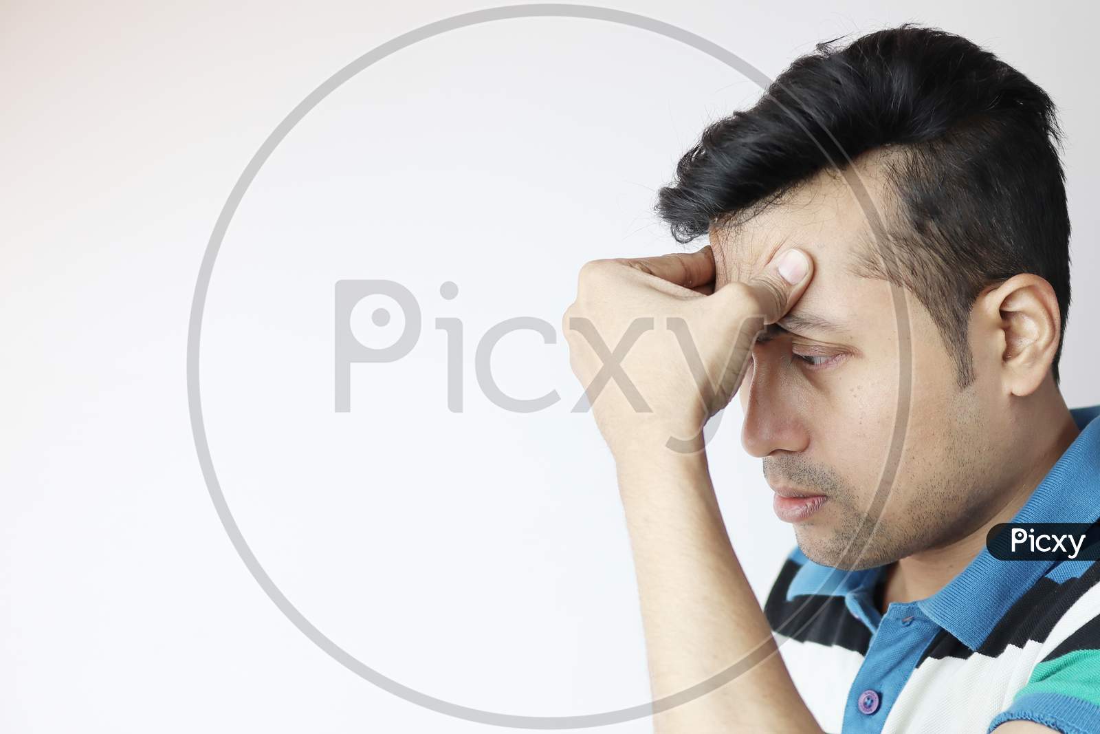 A Young Indian Male With Hands On Forehead With A Very Worried Expression Isolated On White With Copy Space For Text