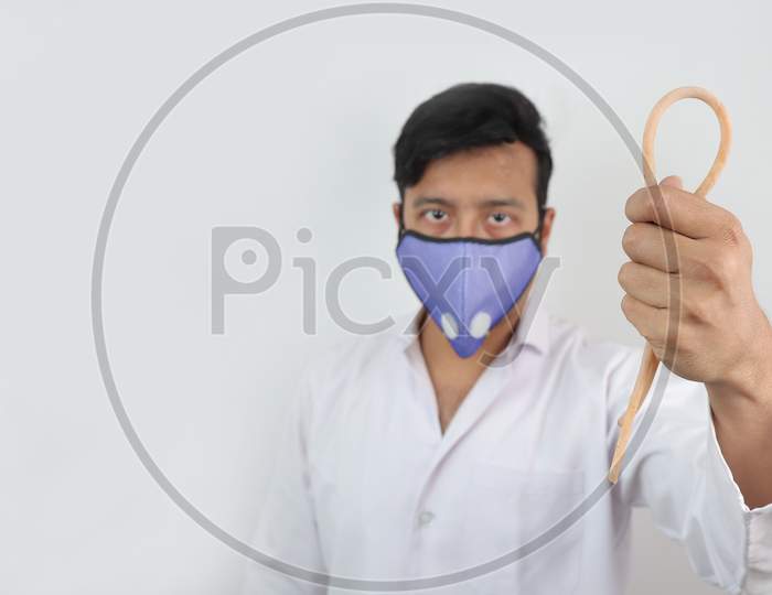 A Medical Professional In White Coat And N 99 Mask With A Tourniquet In Hand In White Background With Space For Text.