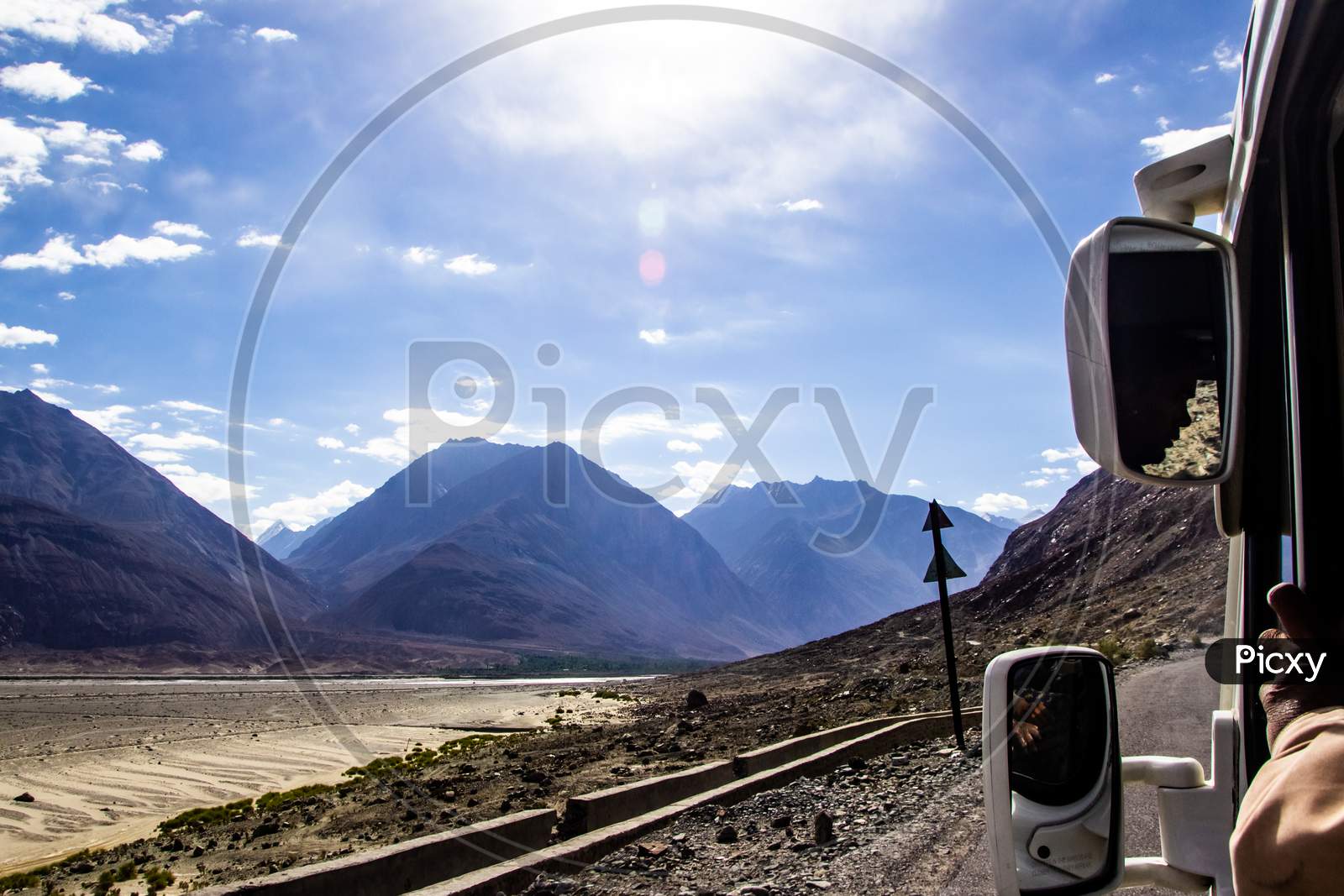 View Of Roads Of Ladakh Kashmir From Car Window While Travelling In A Car With Hills And Blue Sky.