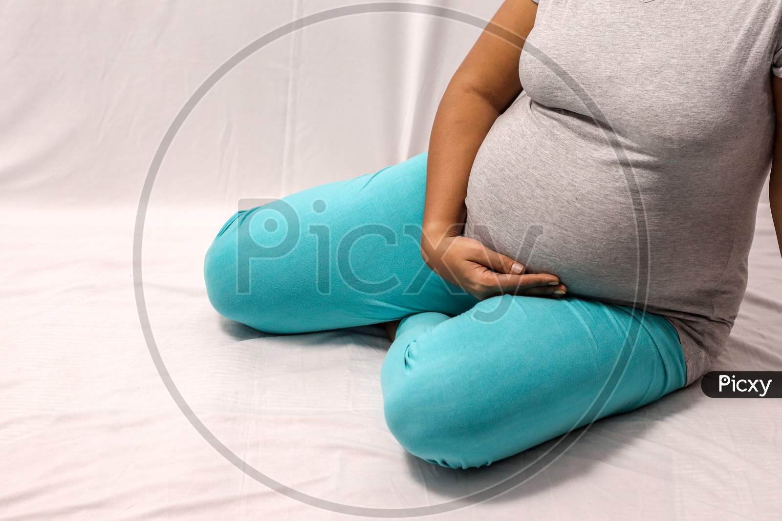 Body Shot Of A Pregnant Lady With Hands On Belly