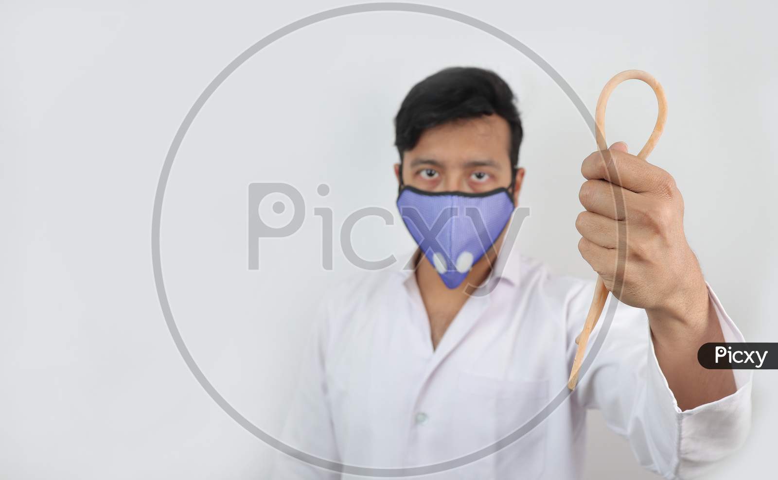 A Medical Professional In White Coat And N 99 Mask With A Tourniquet In Hand In White Background With Space For Text.