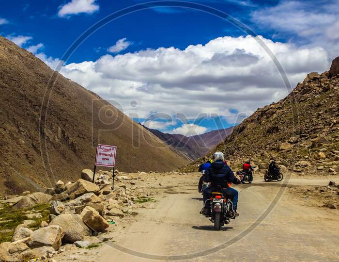 Ladakh,India.  Gang Of Bike Riders Riding Across Rocky Highway Of Ladakh, Kashmir, India