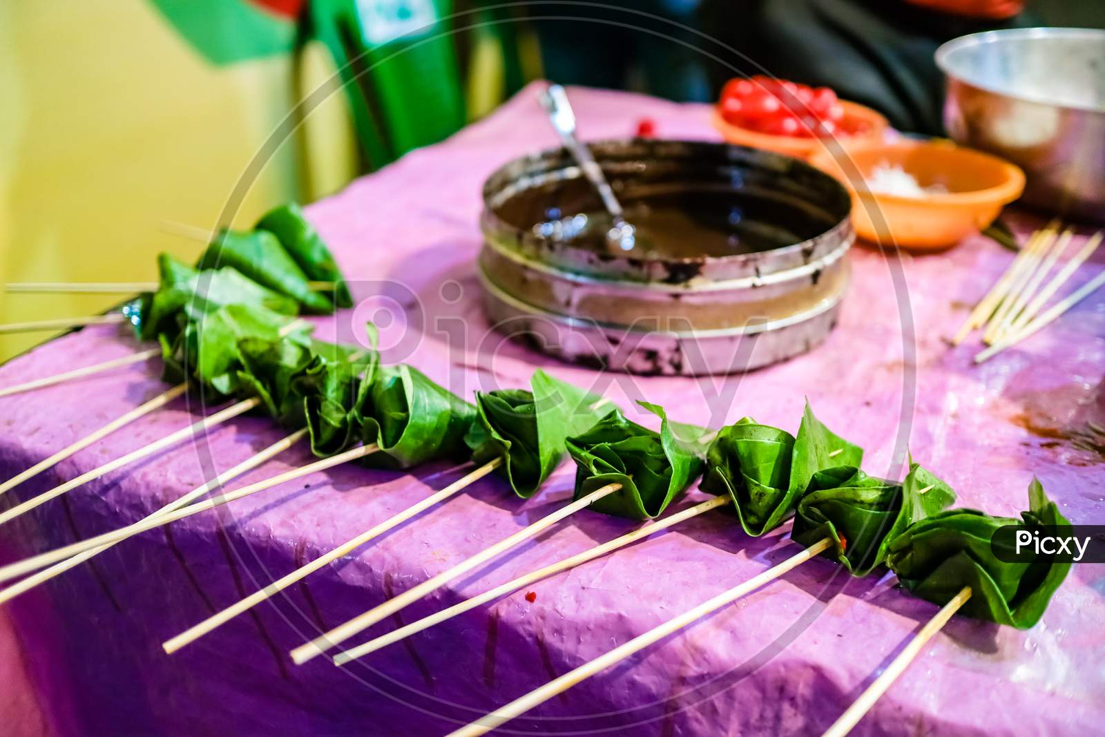 Cone Of Betel Leaf Being Coated With Chocolate Syrup To Form Chocolate Paan With Selective Focus And Blurred Background.