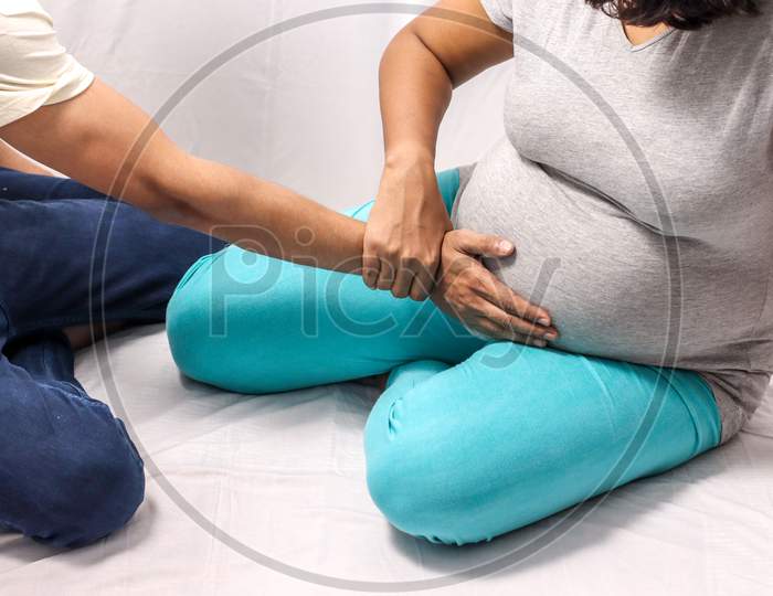 Body Shot Of A Pregnant Lady With Hand With Hands Of Husband On Belly